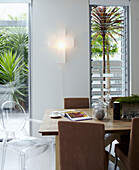 Mismatched chairs in dining room with slatted glass windows