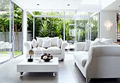 White sofa and table on casters in glass extension with sliding patio doors