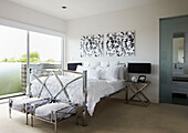 Metal framed furniture in bedroom with black and white artwork