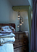 Folded bed covers and lantern holder in 16th Century Welsh farmhouse bedroom