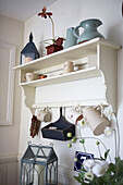 Kitchen jugs and crockery hang on painted open shelving unit