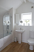 White tiled bathroom with glass shower screen in bathroom of sustainable housing development Gloucestershire