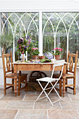 Wooden table and chairs in glass conservatory extension
