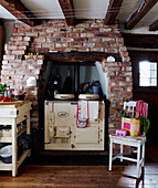 Range oven in brick fireplace of Devon cottage with beamed ceiling