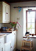 Sunlit window and butler sink in Devon cottage kitchen