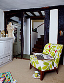 Floral print chair at staircase of Devon cottage 