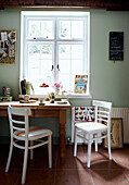 Chairs facing across sunlit wooden kitchen table