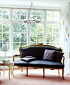 Neu gepolstertes antikes Sofa in einem unbedeckten Gartenfenster