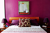Kunstwerk über dem Bett mit blumengemustertem Kissen