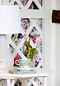 Lamp on side table with cup saucer and cut tulips
