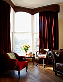 Living room with long red velvet curtains