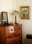 corner of bedroom with chest of drawers and Tiffany lamp