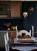 Lit candles on dining table in cottage kitchen