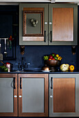 Fruit bowl and picture frame in blue kitchen with muted metallic finish