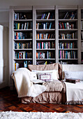 Blankets on cream sofa in front of bookcase in Dublin home