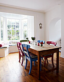 Wooden kitchen table with multicoloured chairs in Dublin home