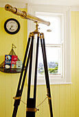 Antique telescope set at window of coastal home