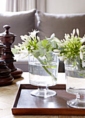 Cut flowers and polished chess pieces with wooden tray in country home