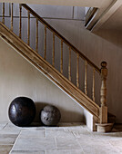 Two stone ball seats under wooden banister at staircase in country home