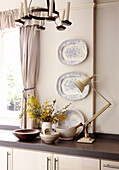 Decorative plates and desk lamp on kitchen worktop in country house