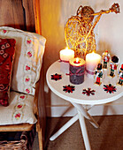 Lit candles and figurines with wicker statue on side table