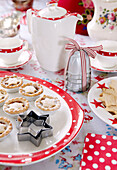 Mince pies and pastry cutters on spotted red plate