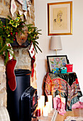 Christmas stockings hang over fireplace with cross stitch on side table