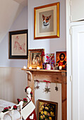 Lit candles on wooden fireplace with artwork in bedroom