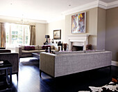 Grey sofas in front of fireplace in sunlit room