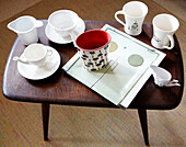 White teacups and milk jug on wooden side table
