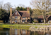 Brick house by water in Forest Row Surrey England UK