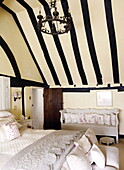 Dramatic beamed ceiling in bedroom of Forest Row farmhouse Surrey England UK