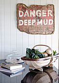 Gardening rug and books on polished kitchen counter with a ' Danger Deep Mud' sign Hampshire home England UK