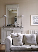 Anrichte mit passenden Lampen und Spiegel mit Sofa im Wohnzimmer eines Landhauses in Tunbridge Wells, Kent, England, UK