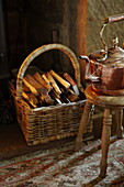 Kindling in log basket with brass kettle at fireside of Hexham country house Northumberland England UK