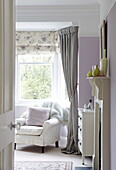 Sessel am Fenster eines Schlafzimmers in einem Haus in Harrogate, Yorkshire, England UK
