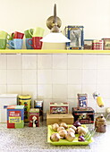 Bright cups and storage tins on kitchen shelving in Abbekerk Dutch province of North Holland in the municipality of Medemblik