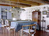 Dining table below hanging floral wreaths in Abbekerk home in the Dutch province of North Holland municipality of Medemblik