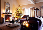 Lit candles and tree in living room of festive Oxfordshire home, England, UK