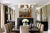 Polished wooden dining table and mirrored alcoves and artwork canvas in classic London home, England, UK