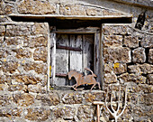 Metallpferd auf dem Fensterbrett eines steinernen Nebengebäudes im ländlichen Oxfordshire, England, UK