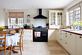 Auflaufform auf Gaskochfeld mit schwarzem Ofen in einer Küche in Oxfordshire, England, Vereinigtes Königreich