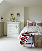 White chest of drawers at bedside in Oxfordshire home, England, UK