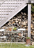 Holzstapel unter einer Holztreppe im Außenbereich eines Hauses in Woodstock, Oxfordshire, England, Vereinigtes Königreich