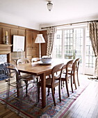Wooden dining table with Philippe Starck Ghost Chair in Woodstock home, Oxfordshire, England, UK