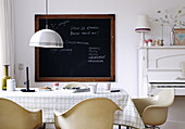 Retro-styled kitchen with blackboard, piano and metallic pendant light in Bussum home, Netherlands
