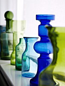 Retro glassware on windowsill in hues of green and blue in Bussum home, Netherlands