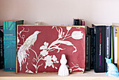 Wallpaper sample on bookshelf with figurines of a girl and a cat, Amsterdam, Netherlands
