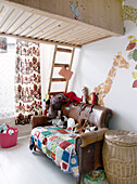 Crochet blanket and soft toys on brown leather sofa under mezzanine bed in child's room, Amsterdam, Netherlands