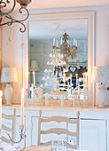 Candle stand reflected in dining room mirror with model furniture in Derbyshire farmhouse England UK